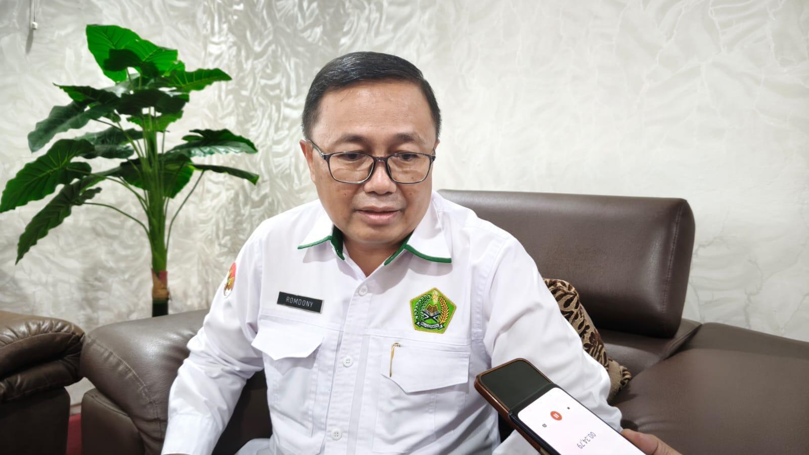 Kluster tiga pot tanaman berbeda ukuran (Philodendron, Peperomia, dan Kaktus mini) di atas rak bertingkat sudut ruang baca.